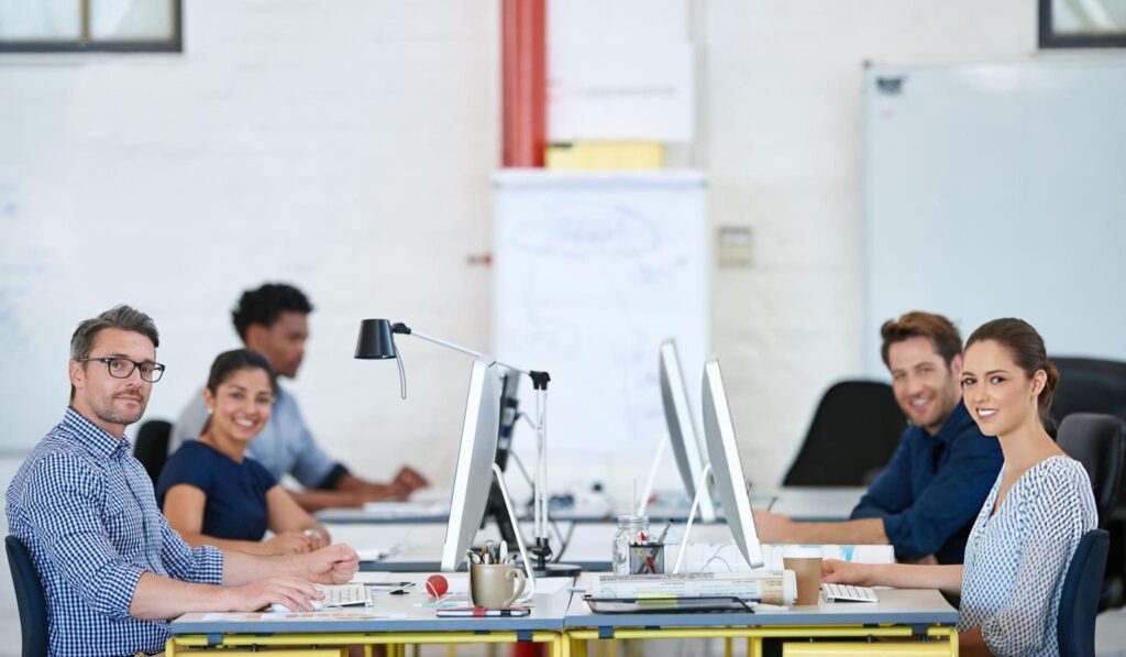 Creative web team working in a modern, diverse agency office.